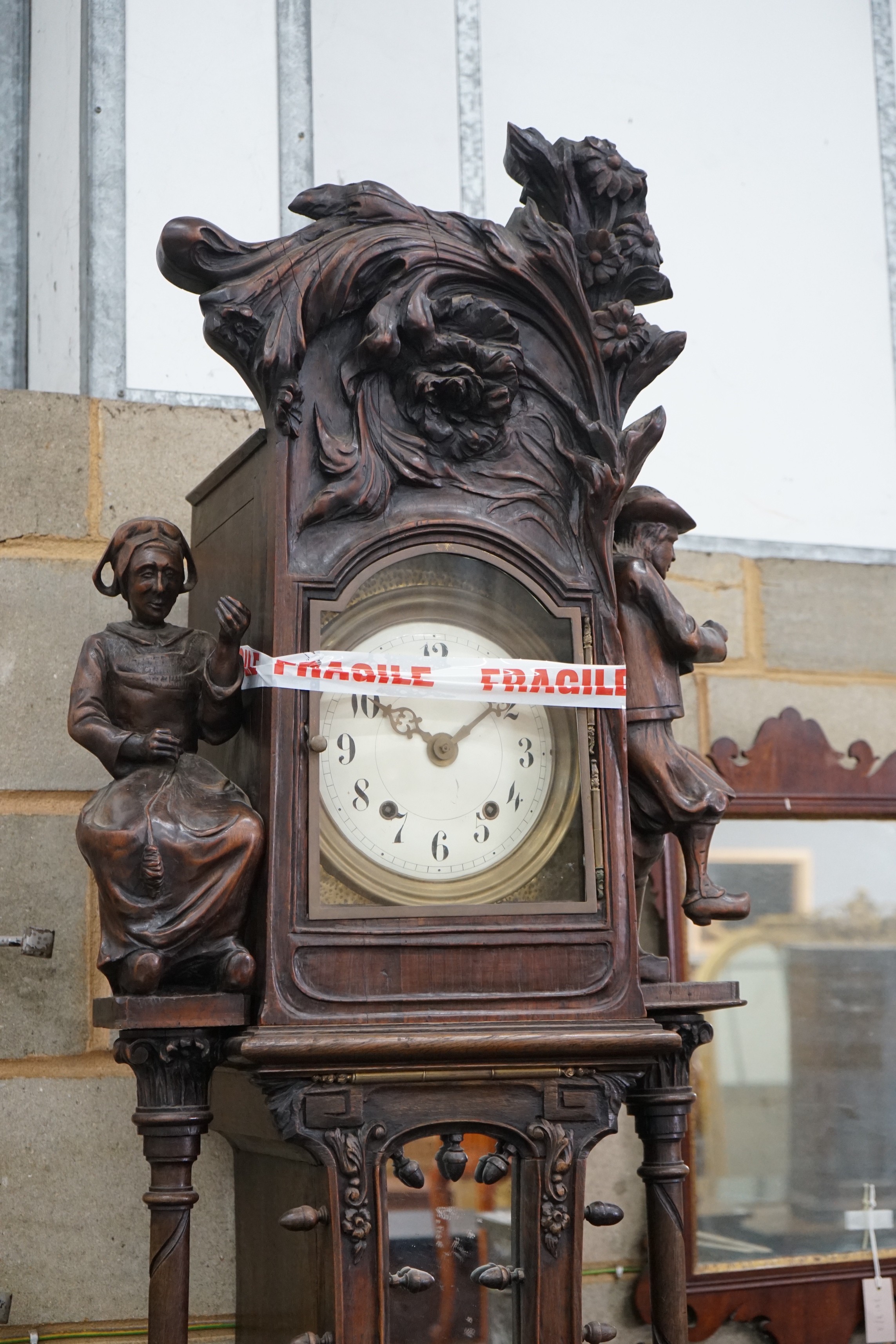 An early 20th century Flemish carved oak and walnut longcase clock, height 240cms.
